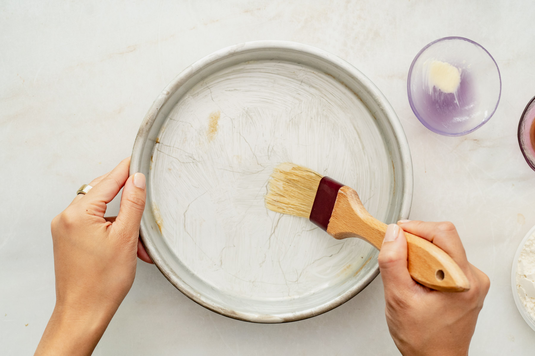 buttering baking dish with a pastry brush.