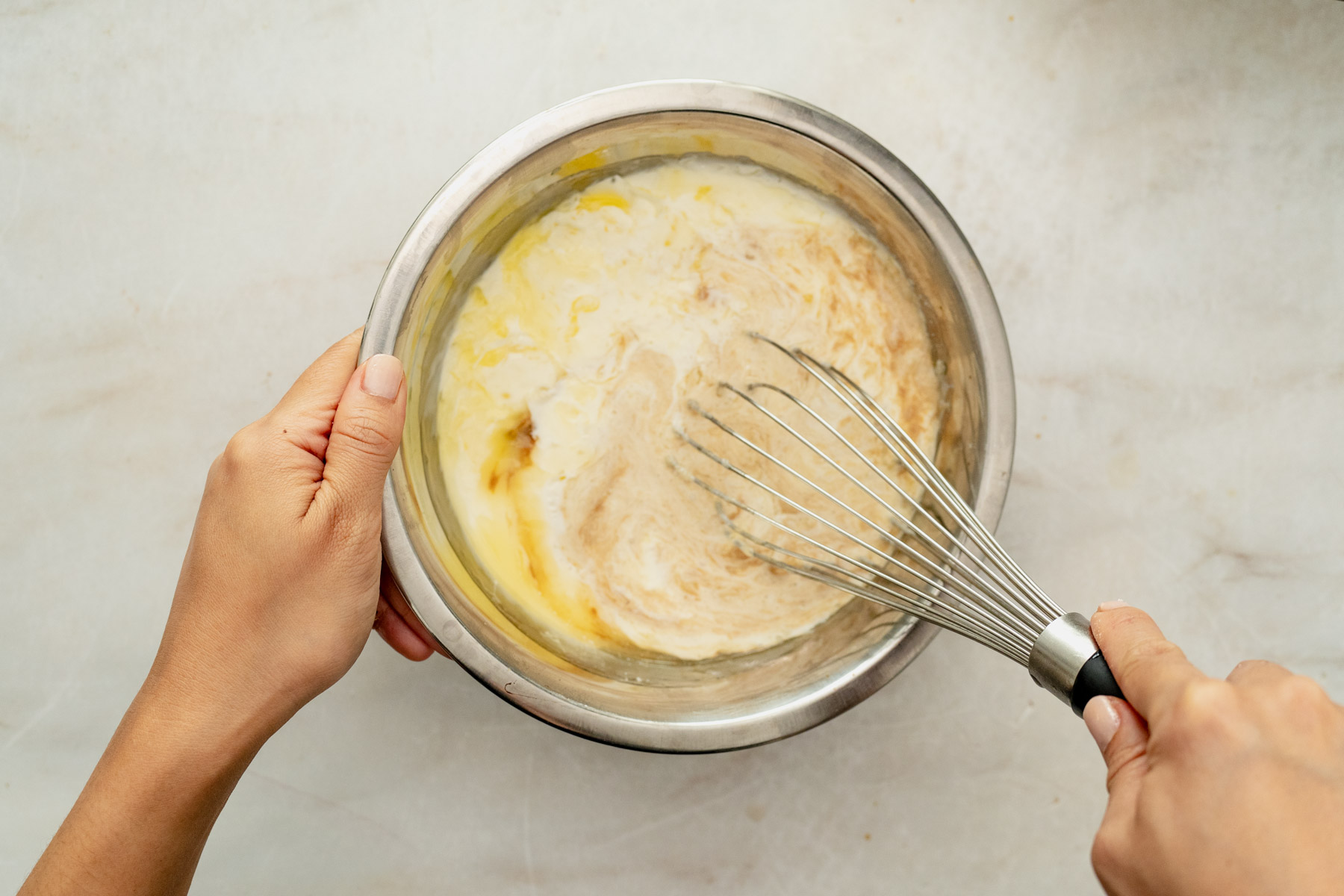 wet and dry ingredients being whisked in a bowl.