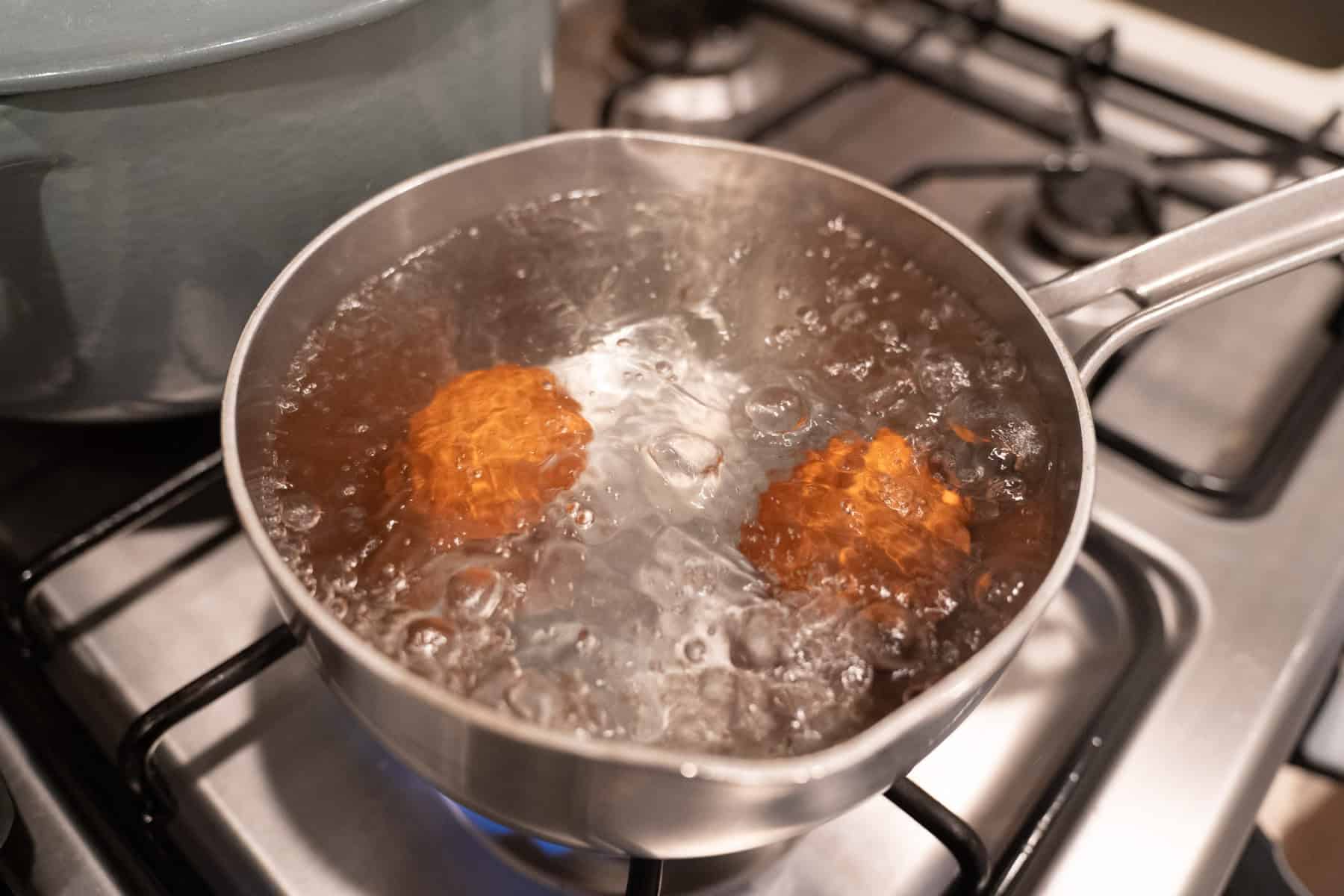 boiling eggs in a small saucepan.