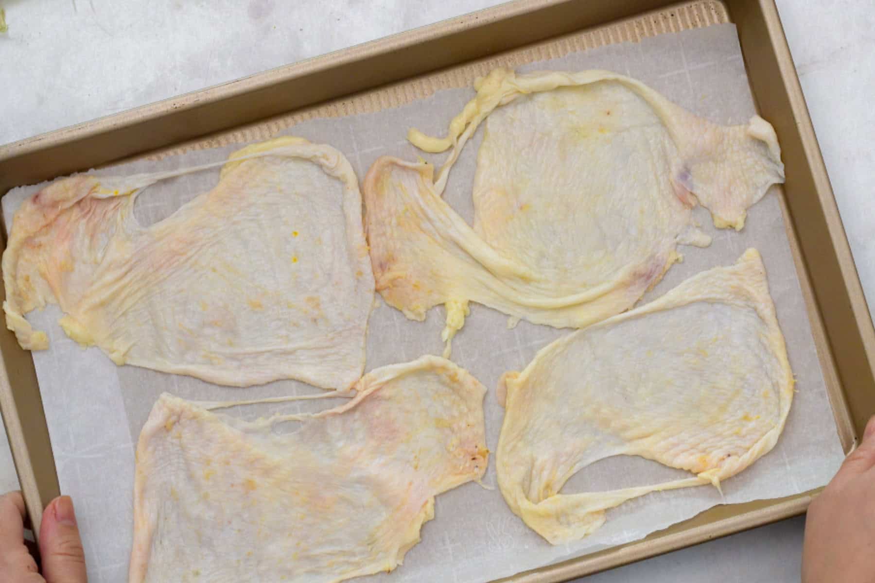chicken skin on a baking sheet with parchment paper.