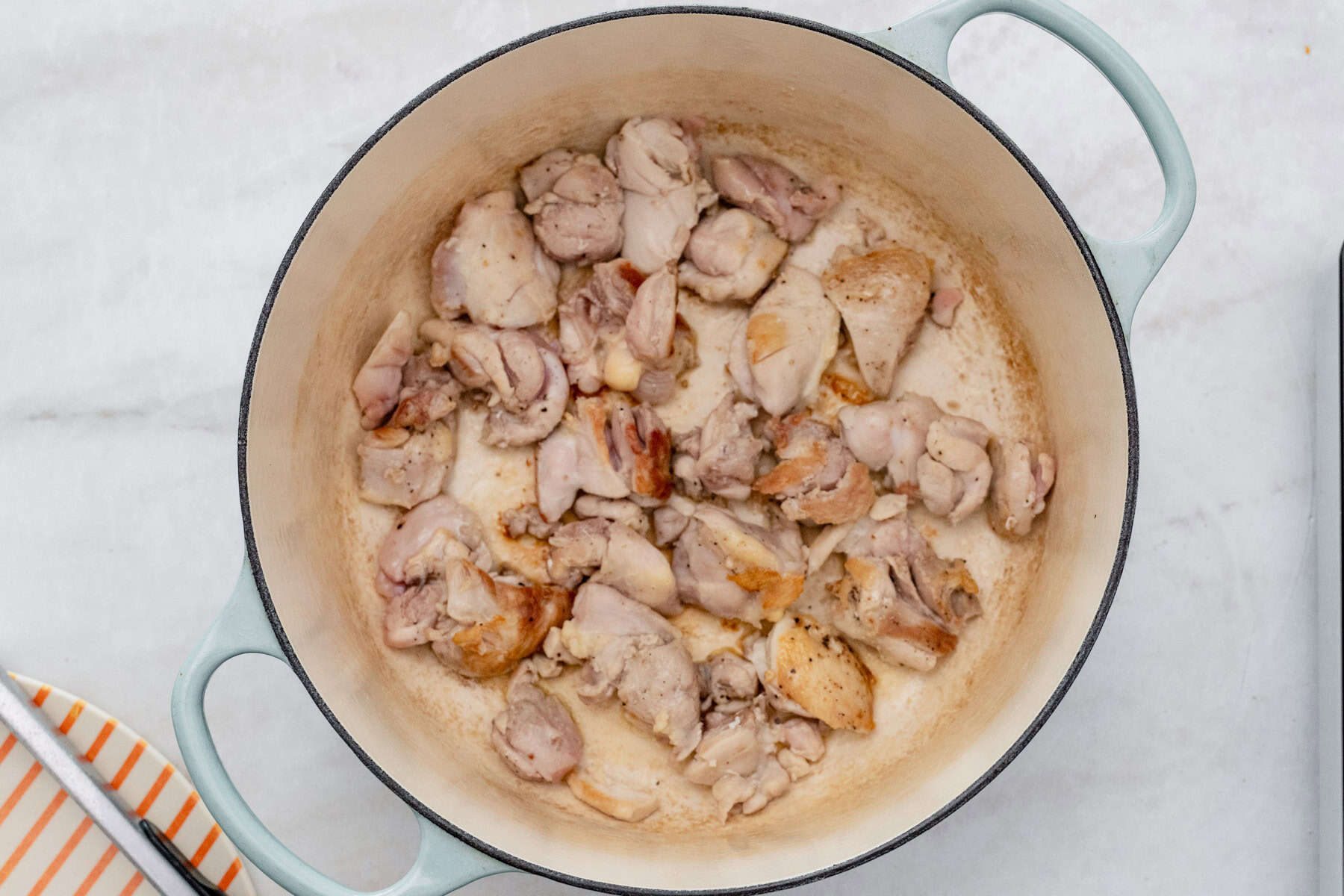 searing chicken in a pot.