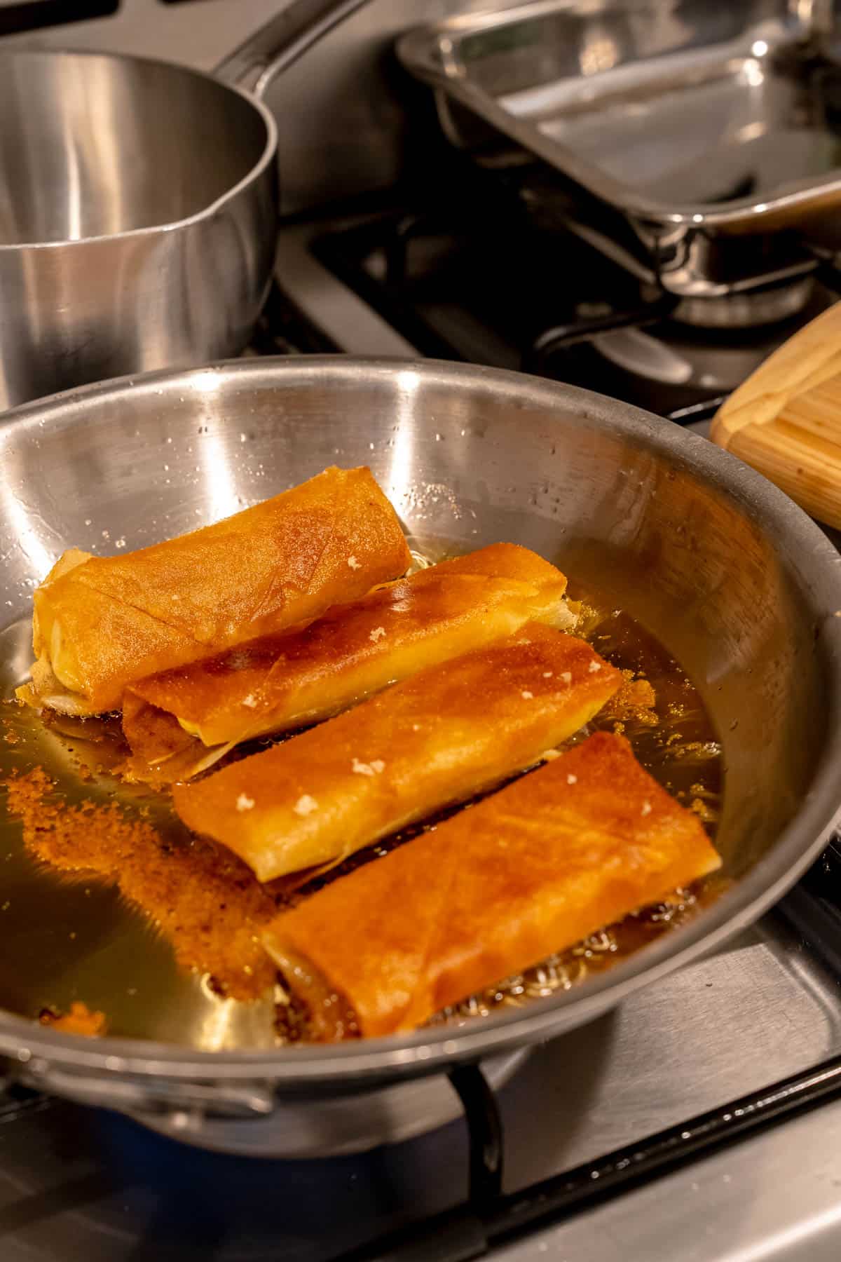 4 turon frying in a pan.