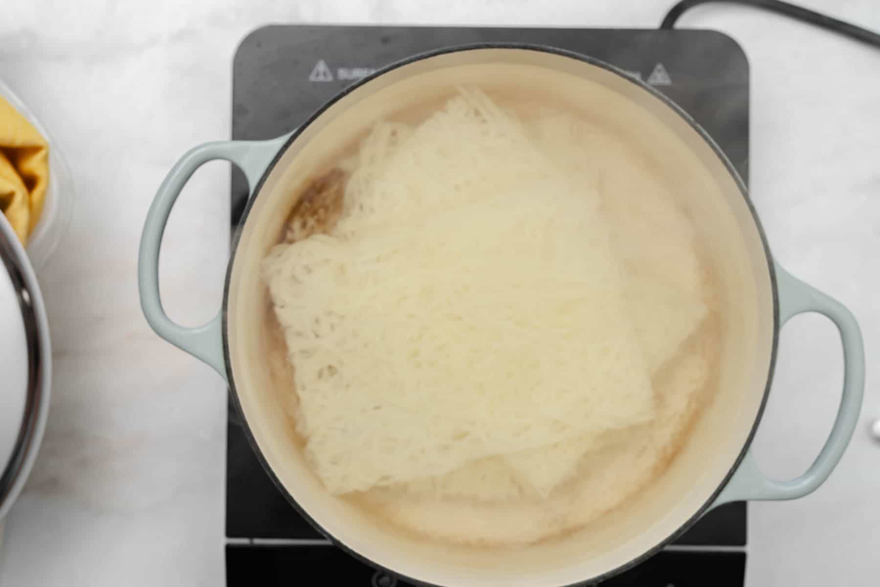 noodles cooking in a dutch oven.