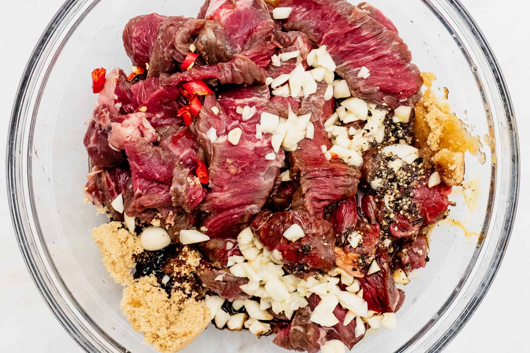 beef tapa marinating in a bowl.