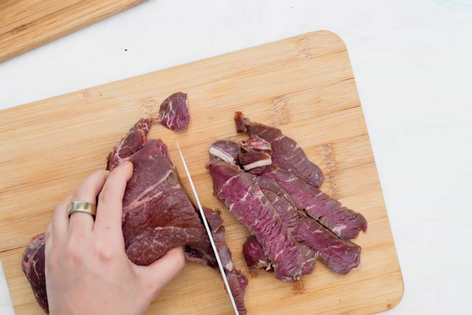 slicing sirloin on cutting board.