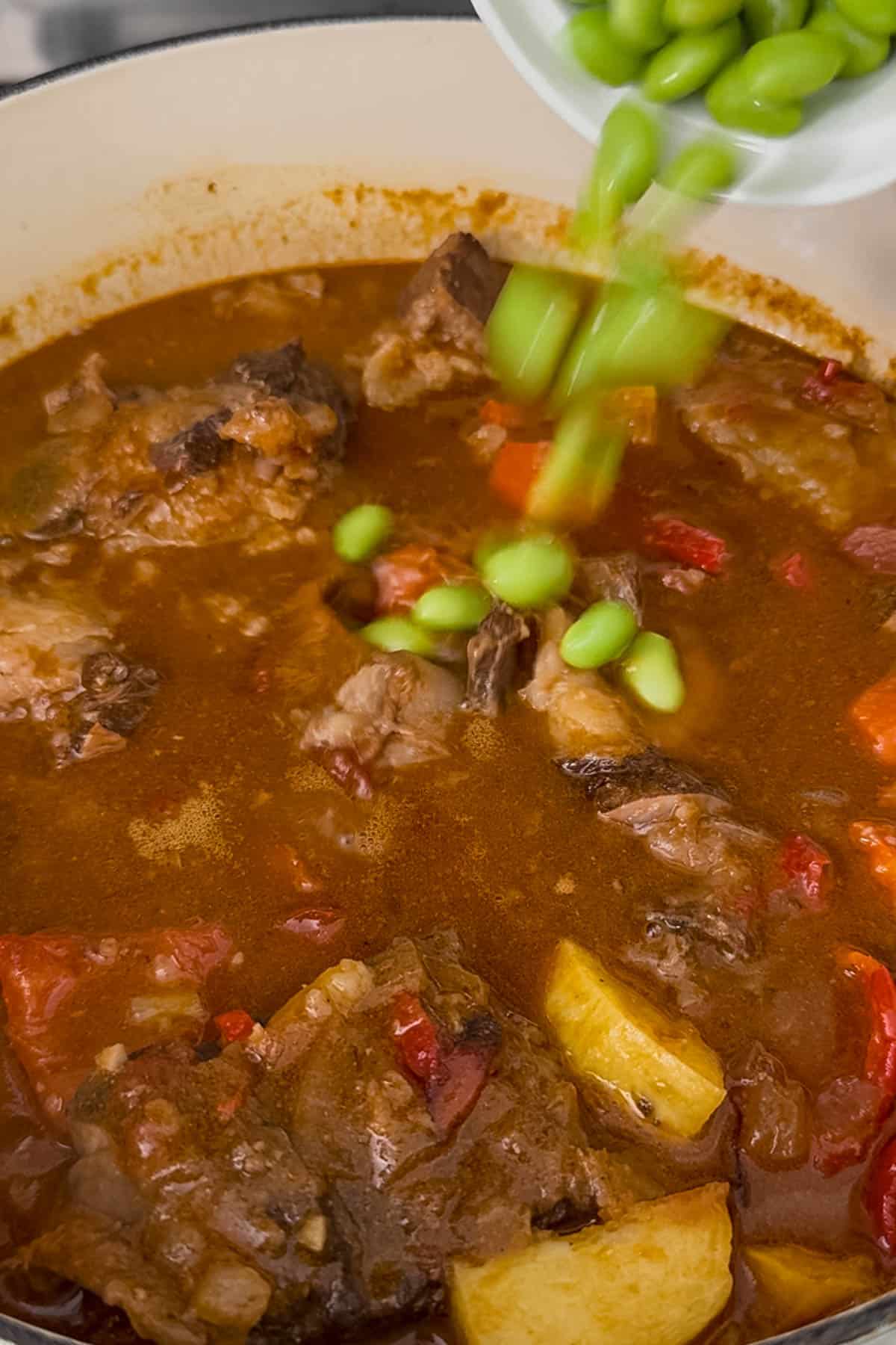 adding edamame into the the beef kaldereta.