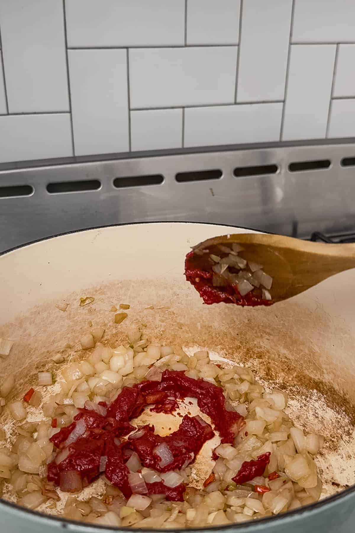 adding tomato paste to aromaticsvin dutch oven.