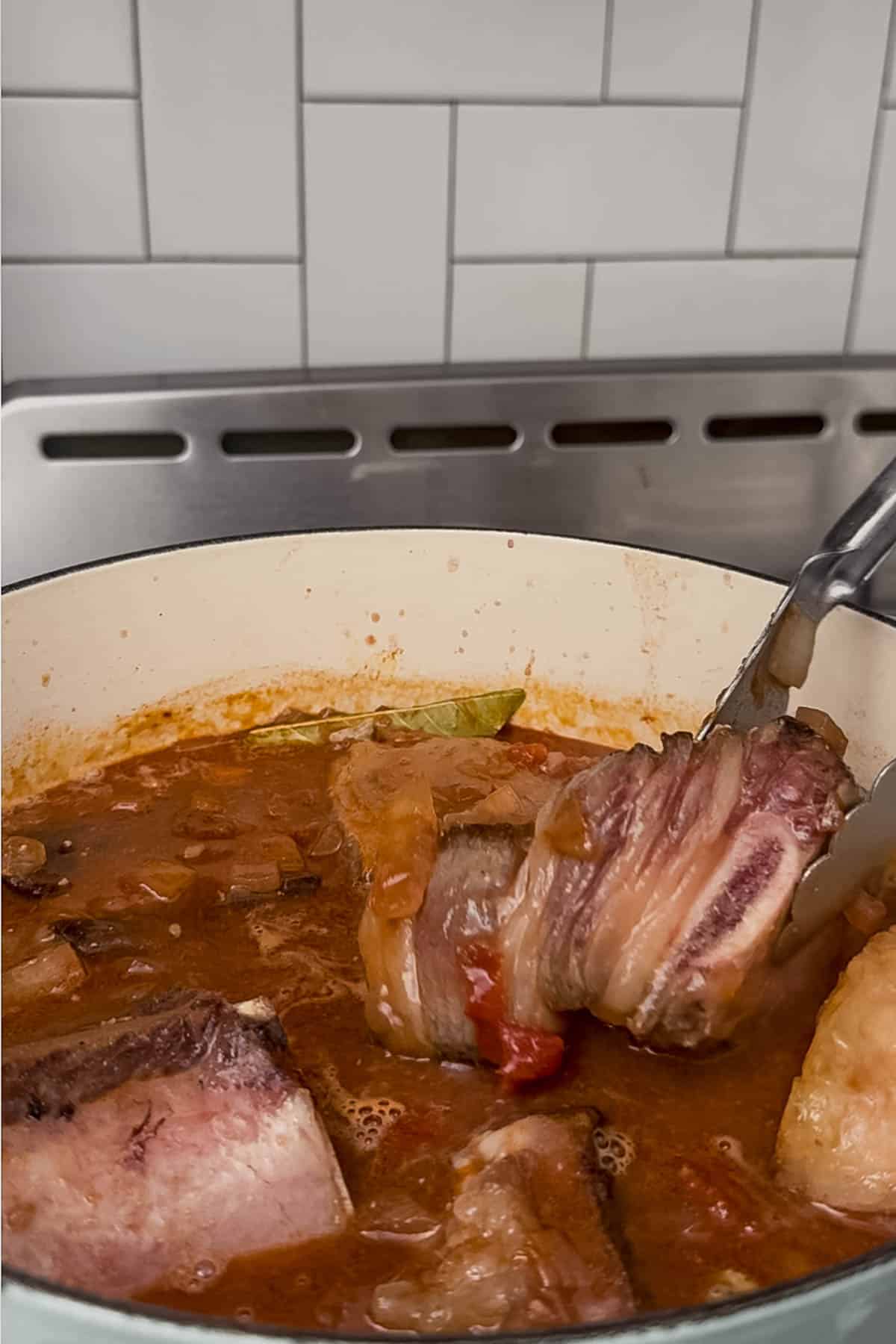 nestling short ribs into the sauce.