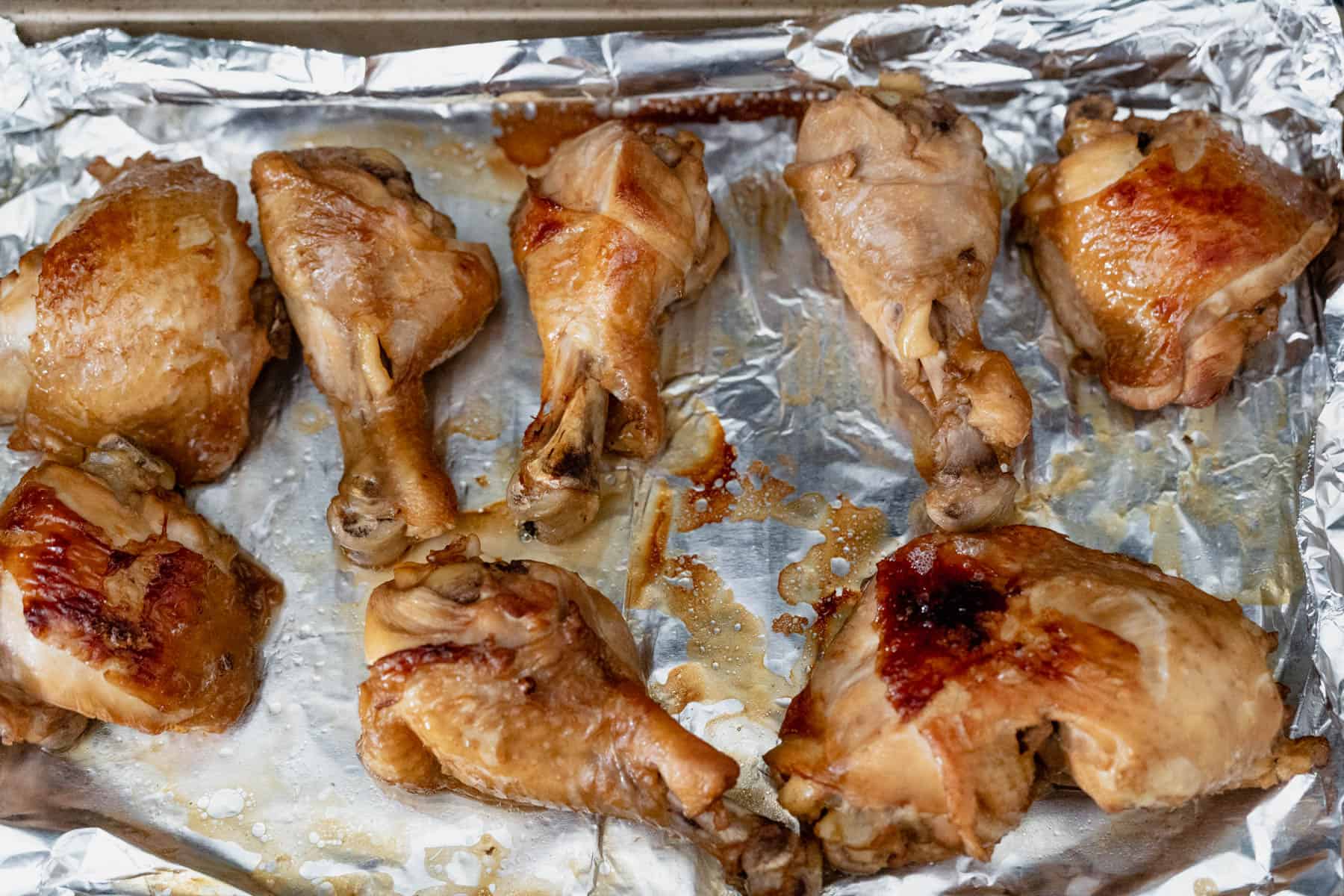 broiled chicken on foil lined baking tray.