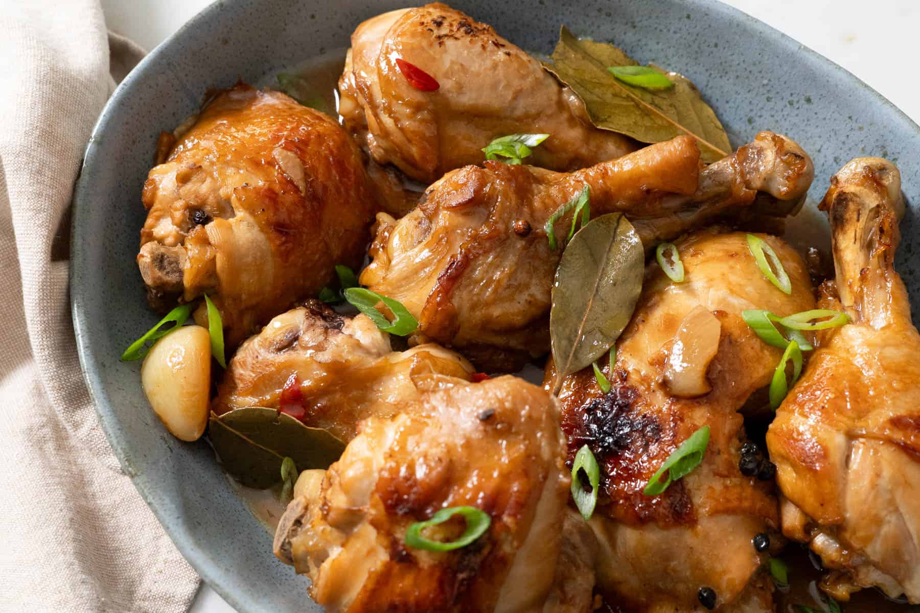chicken adobo served on blue platter.