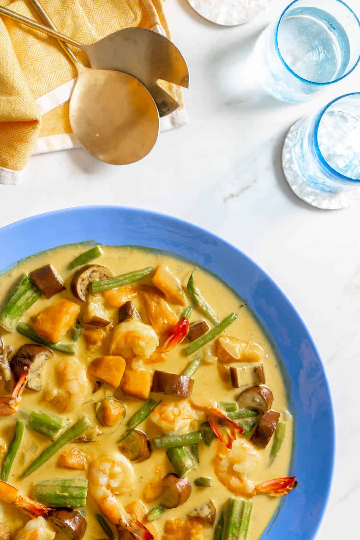 ginataang gulay filipino vegetables in coconut milk stew on a blue serving plate.