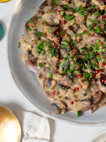 beef lengua with mushroom sauce plated.
