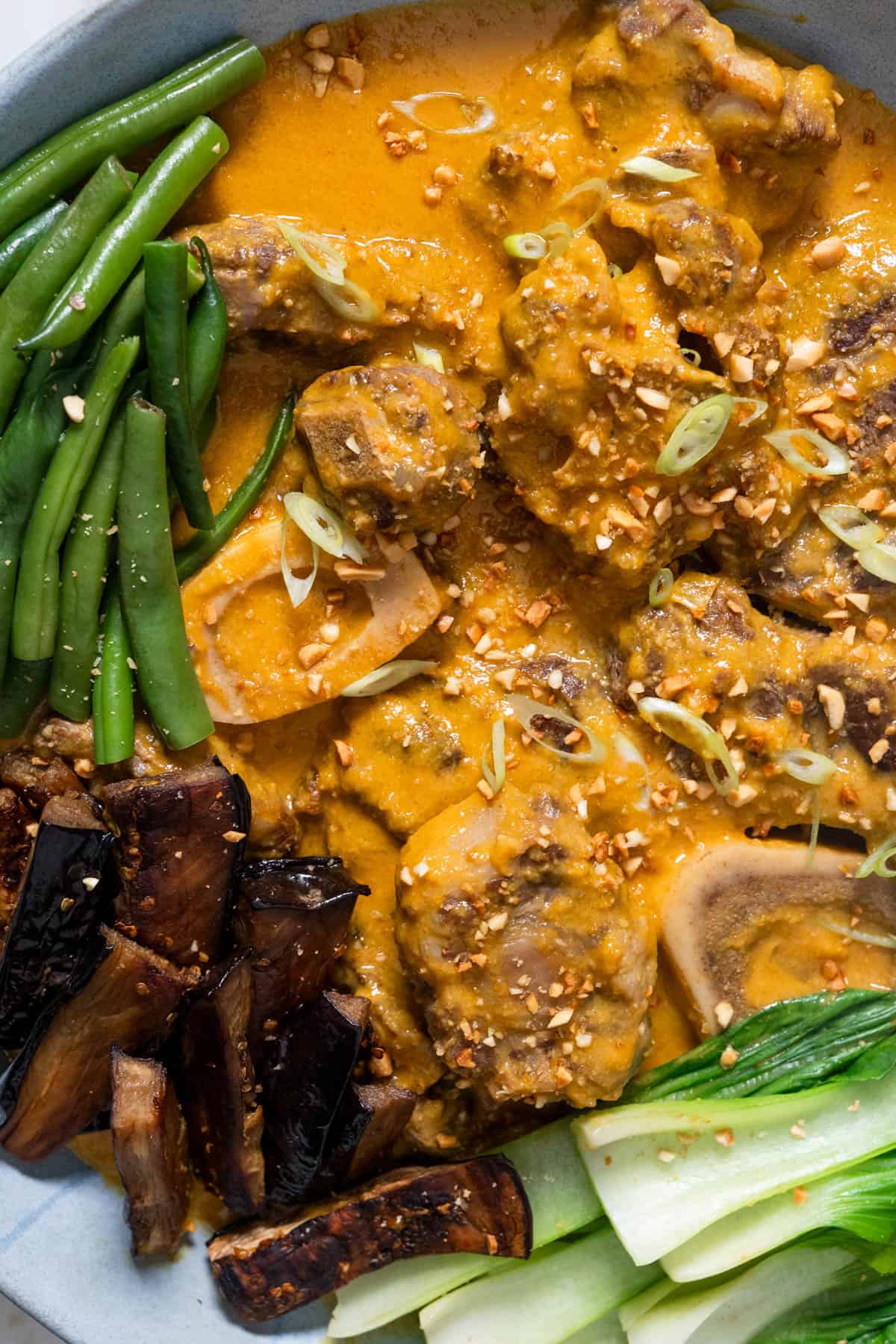 kare kare with vegetables and garnishes.
