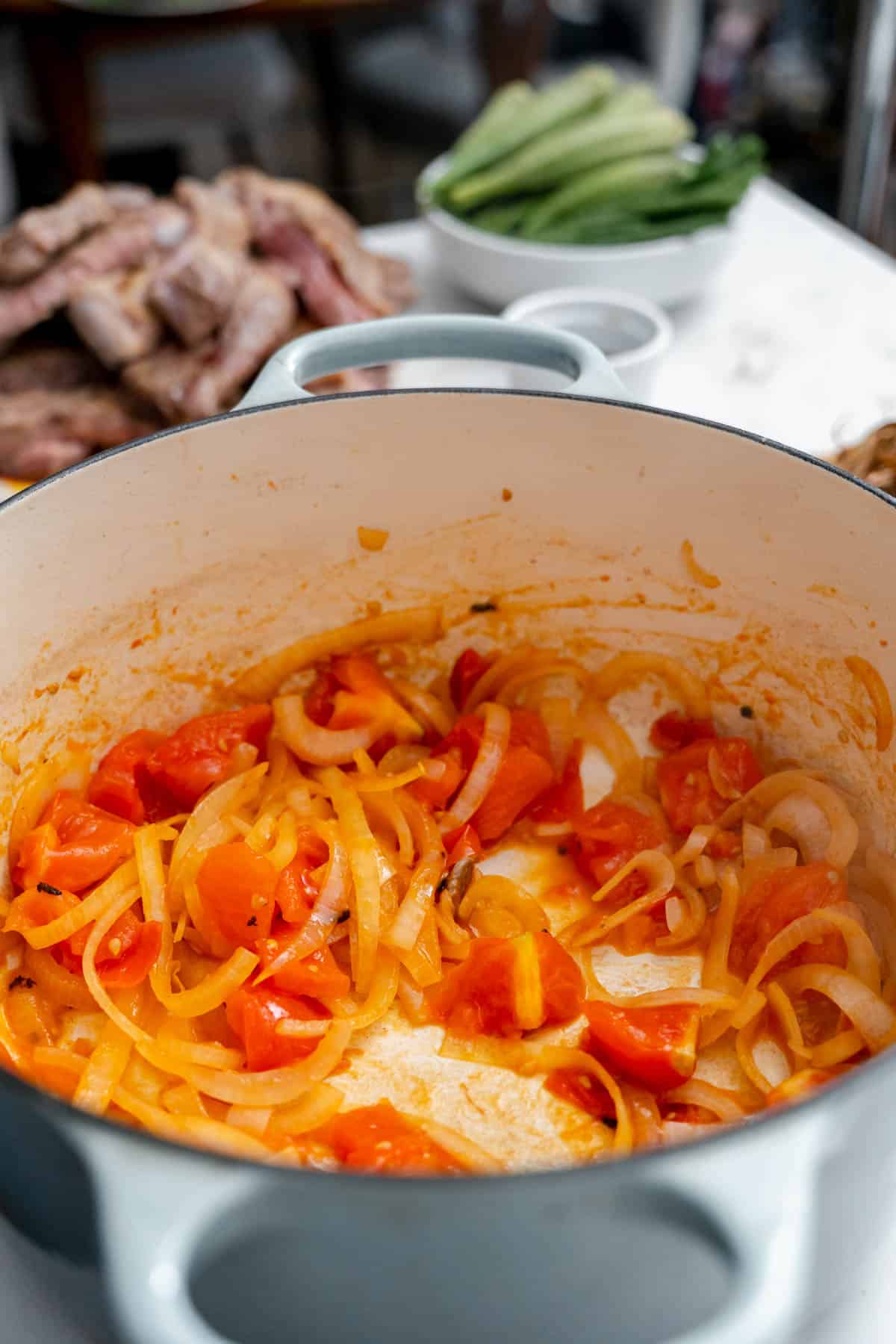 tomatoes and onions sauteeing in pot.